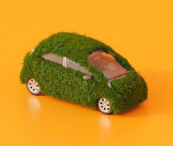 Mini auto cubierto de césped verde sobre un fondo naranja, simbolizando el concepto de vehículo ecológico y transporte sustentable.