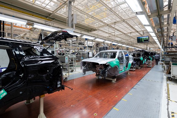 Carrocerías de automóviles en línea de ensamblaje dentro de una planta industrial, en proceso de fabricación.