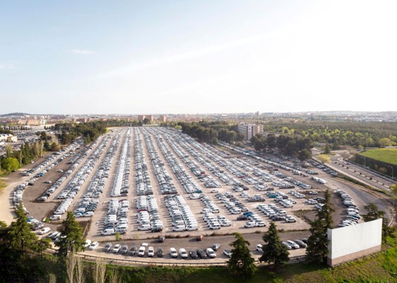 Estacionamiento gigante lleno de autos organizados en filas rectas.